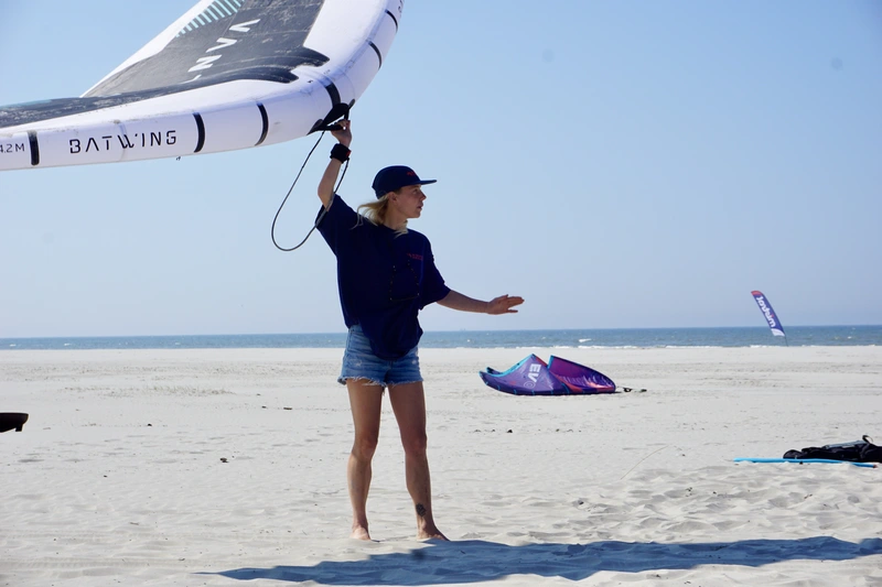 Wingfoil instructeur op het strand theorie les aan het geven.