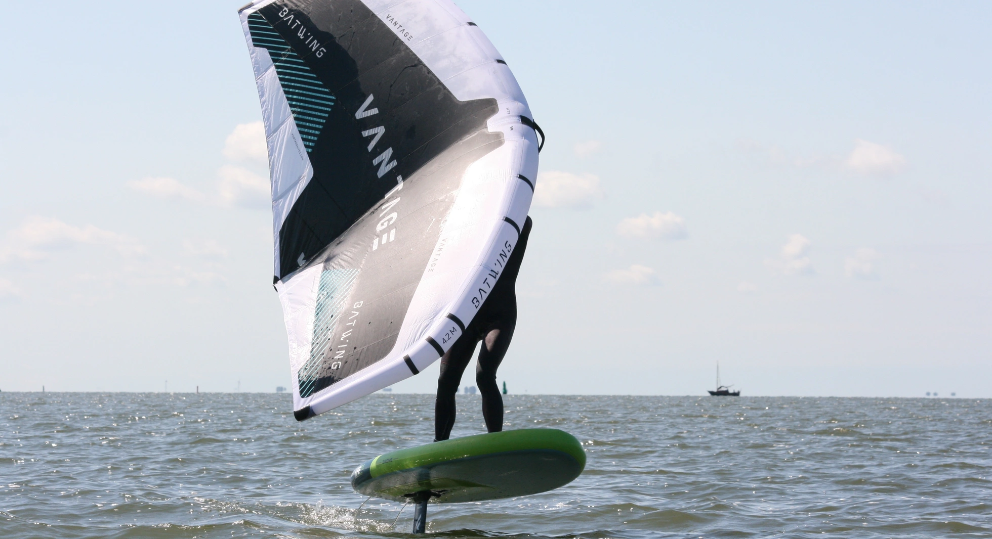 Wingfoil instructeur wingfoiled vliegt op de hydrofoil tijdens een les