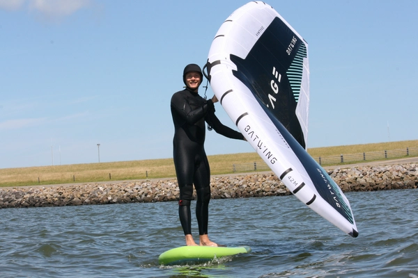 Wingfoil instructeur geeft een les voorbeeld hoe je moet wingsurfen